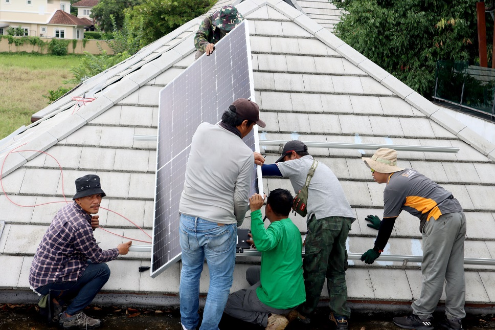 Hoymiles-microinverter-installation-Workers-are-placing-solar-panels-on-a-rooftop.png